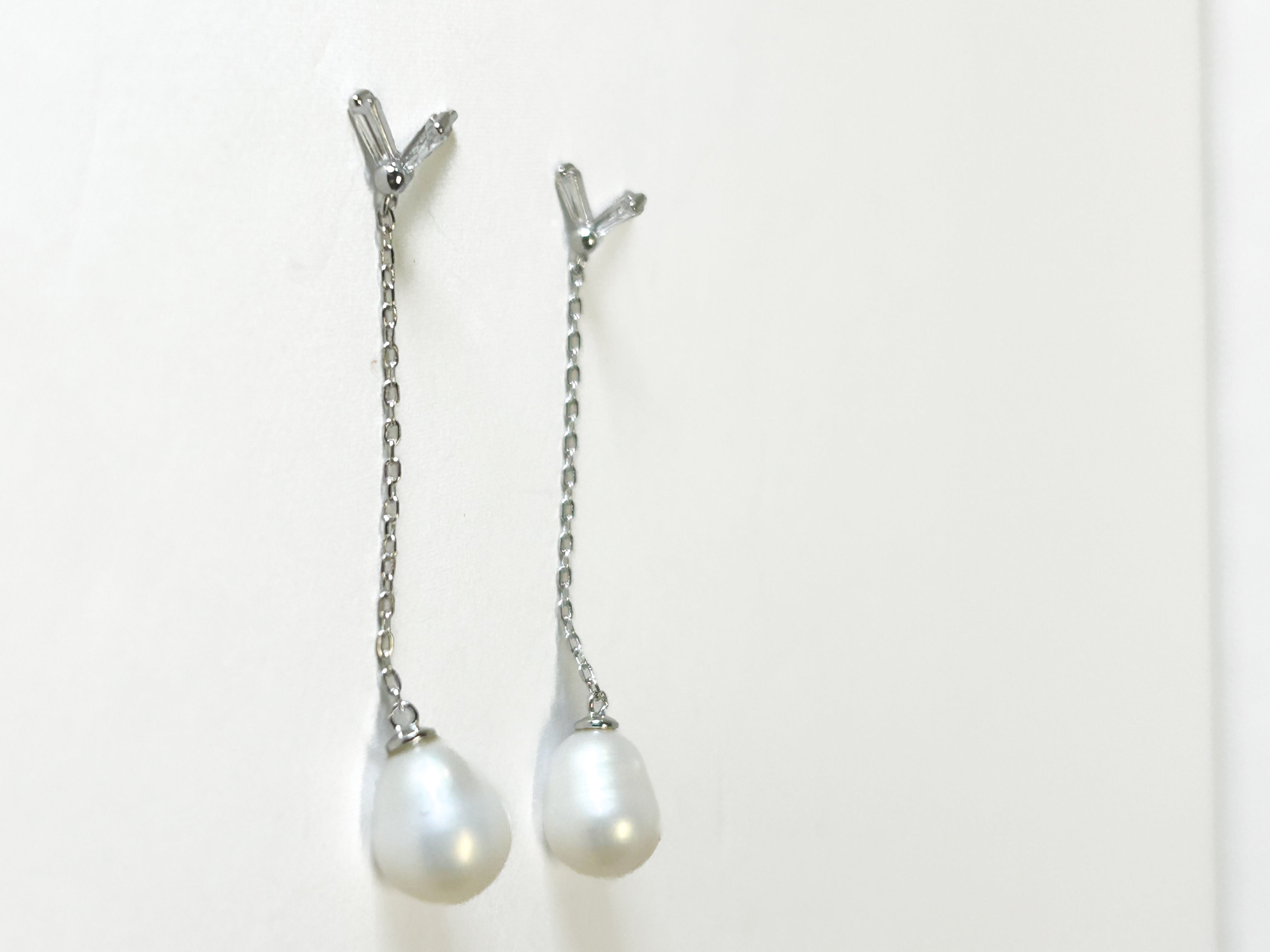 Pearl hair clips with silver chains on a white background